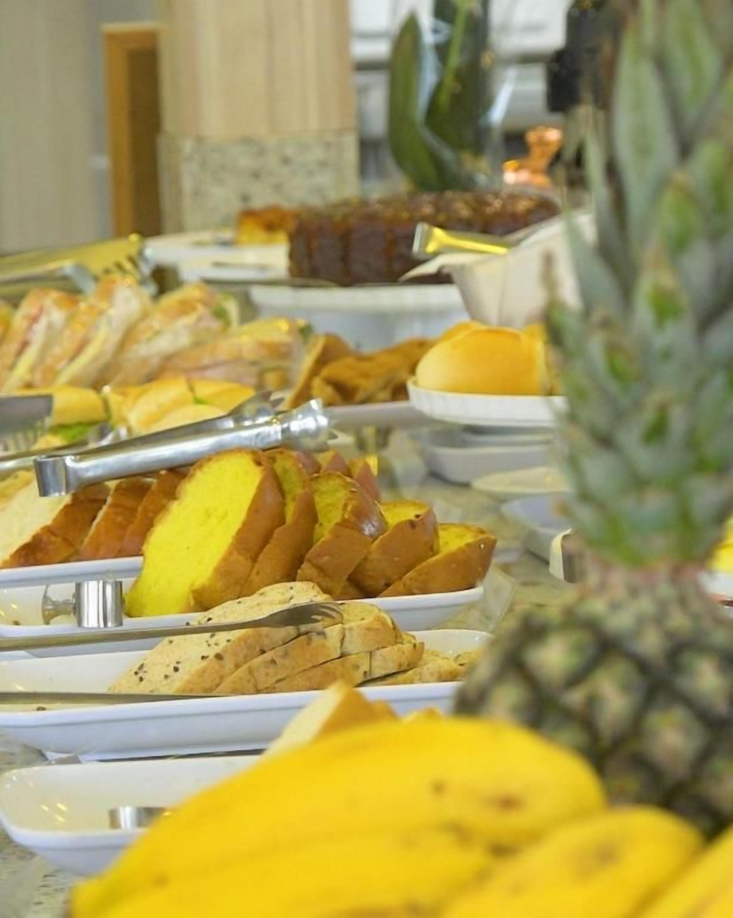 A buffet with various food items including bread, fruits, and a pineapple.