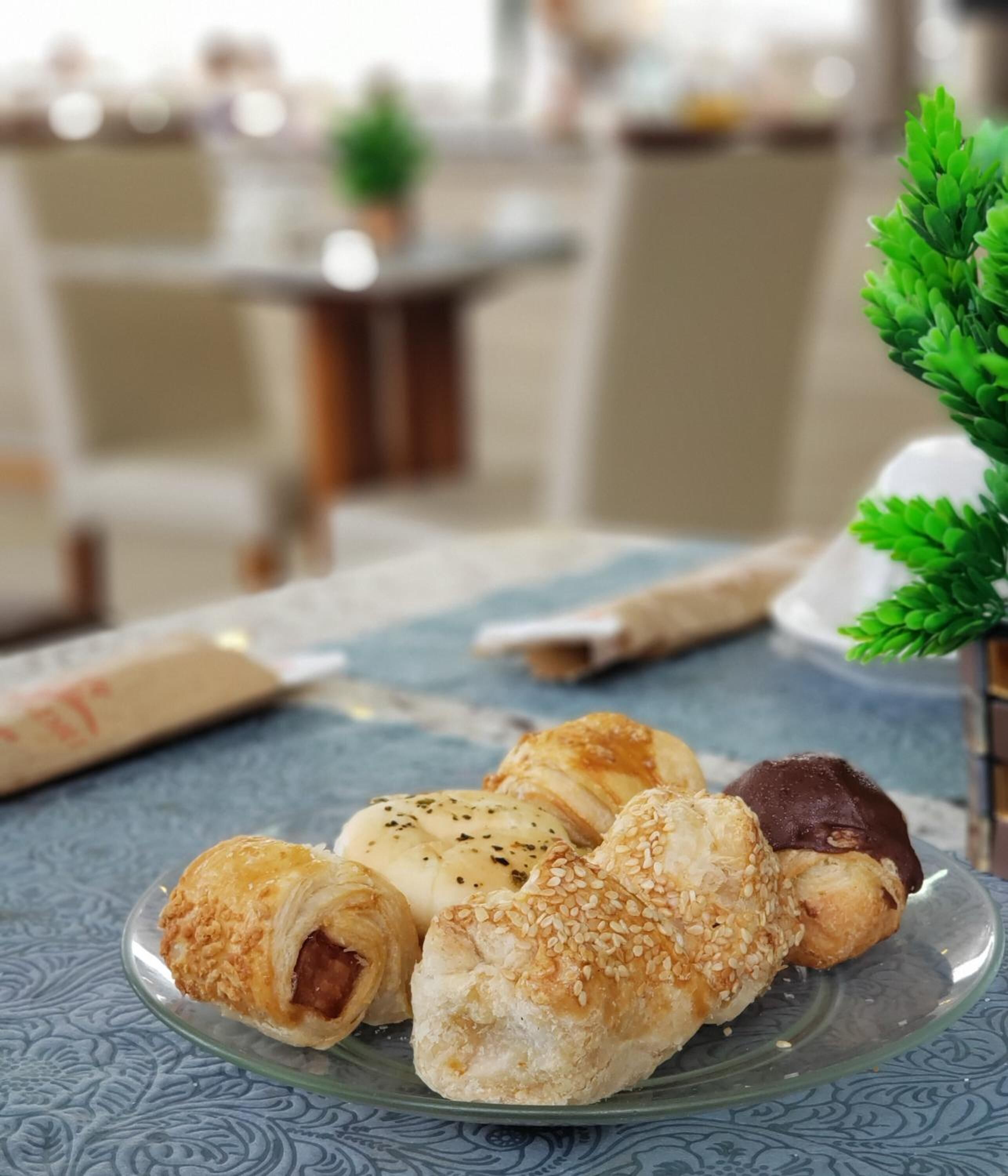 Un plato con varios pasteles sobre una mesa con mantel estampado.