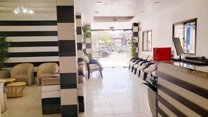 A hotel reception area with a check-in counter, seating area, and a view of the street outside. - Capão da Canoa - Hotel Rediadri (Capao da Canoa)