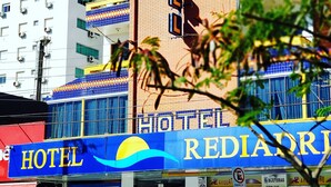 A hotel with a prominent sign reading "HOTEL REDIADR" and a large sun and wave logo. - Capão da Canoa - Hotel Rediadri (Capao da Canoa)