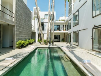 Relax by the pool in our central courtyard, surrounded by lounge chairs and a gravel path. at Drift San Jose del Cabo, a Member of Design Hotels