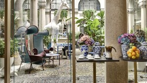 A courtyard with a giraffe sculpture, seating, and decorative vases. - Hotel Indigo Milan - Corso Monforte by IHG (Milan)
