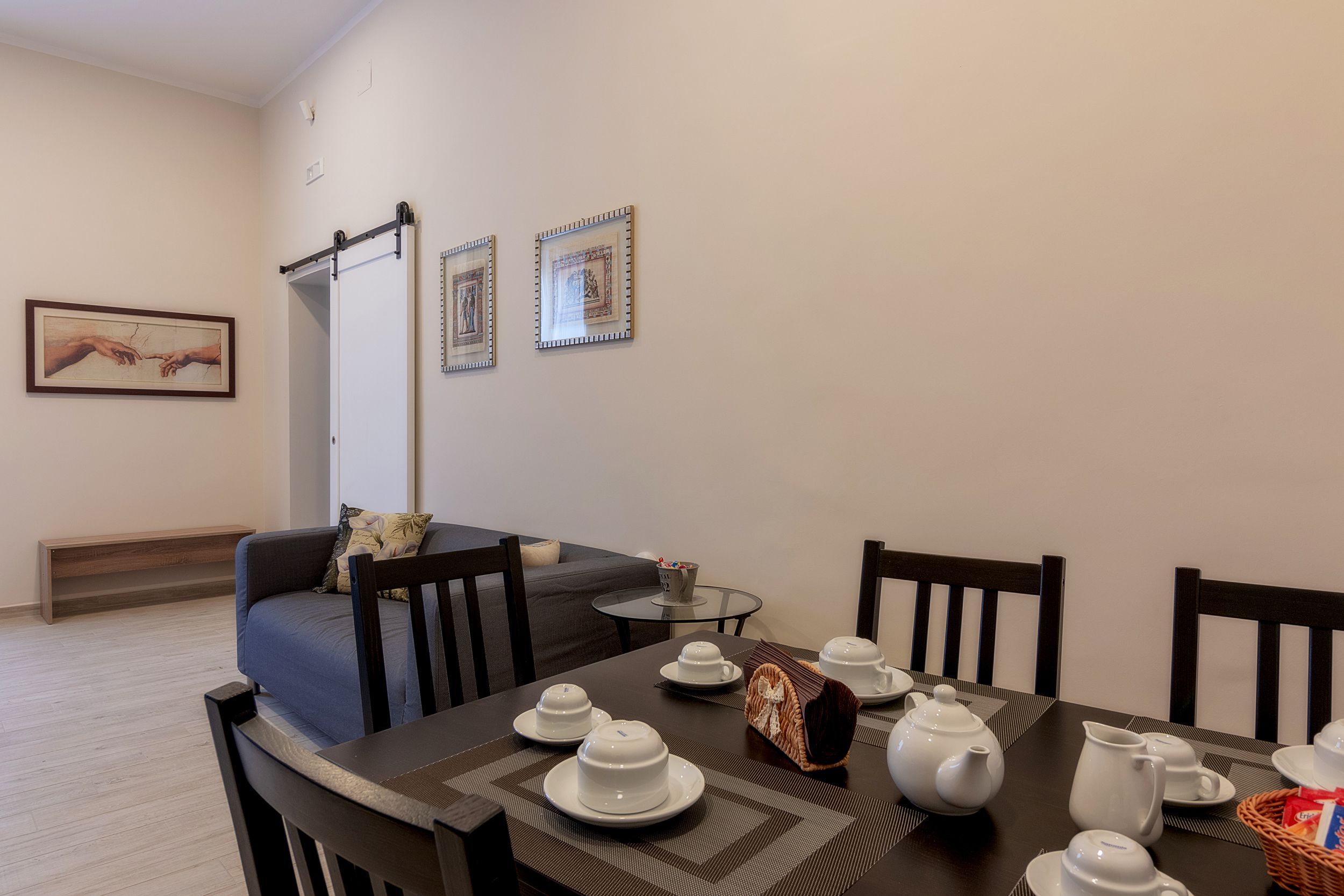 Un coin repas avec une table préparée pour le thé, un canapé et un banc.