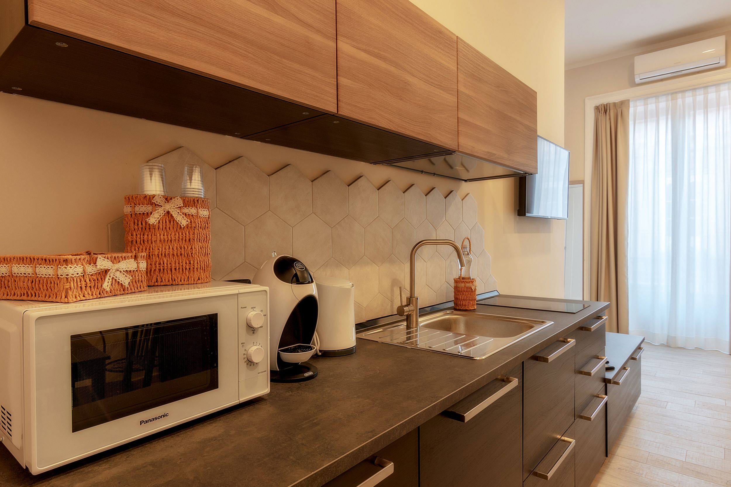 Een moderne keuken met een magnetron, broodrooster en spoelbak.