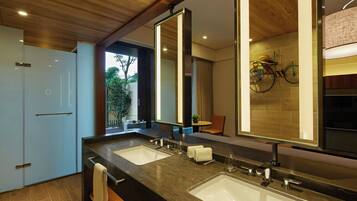 Un baño moderno con dos lavamanos, un espejo grande y techo de madera.