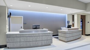Une salle de bain moderne avec deux grands lavabos, un miroir et un téléviseur fixé au mur.