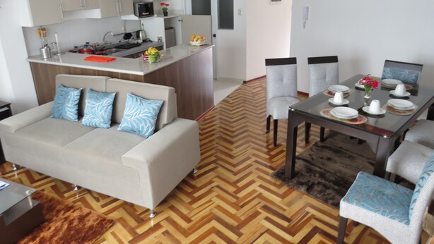 A modern apartment with a dining area, kitchen, and living room. - Apartamentos Quewe (Cusco)