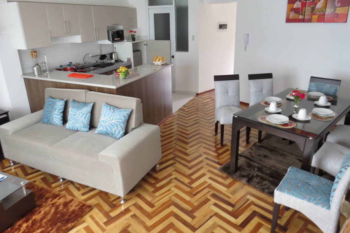 Un appartement moderne comprenant un coin repas, une cuisine et un salon.
