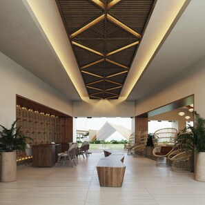 Un vestíbulo espacioso con techo alto que presenta un diseño geométrico de madera, un mostrador de recepción, zona de estar y vistas al exterior.