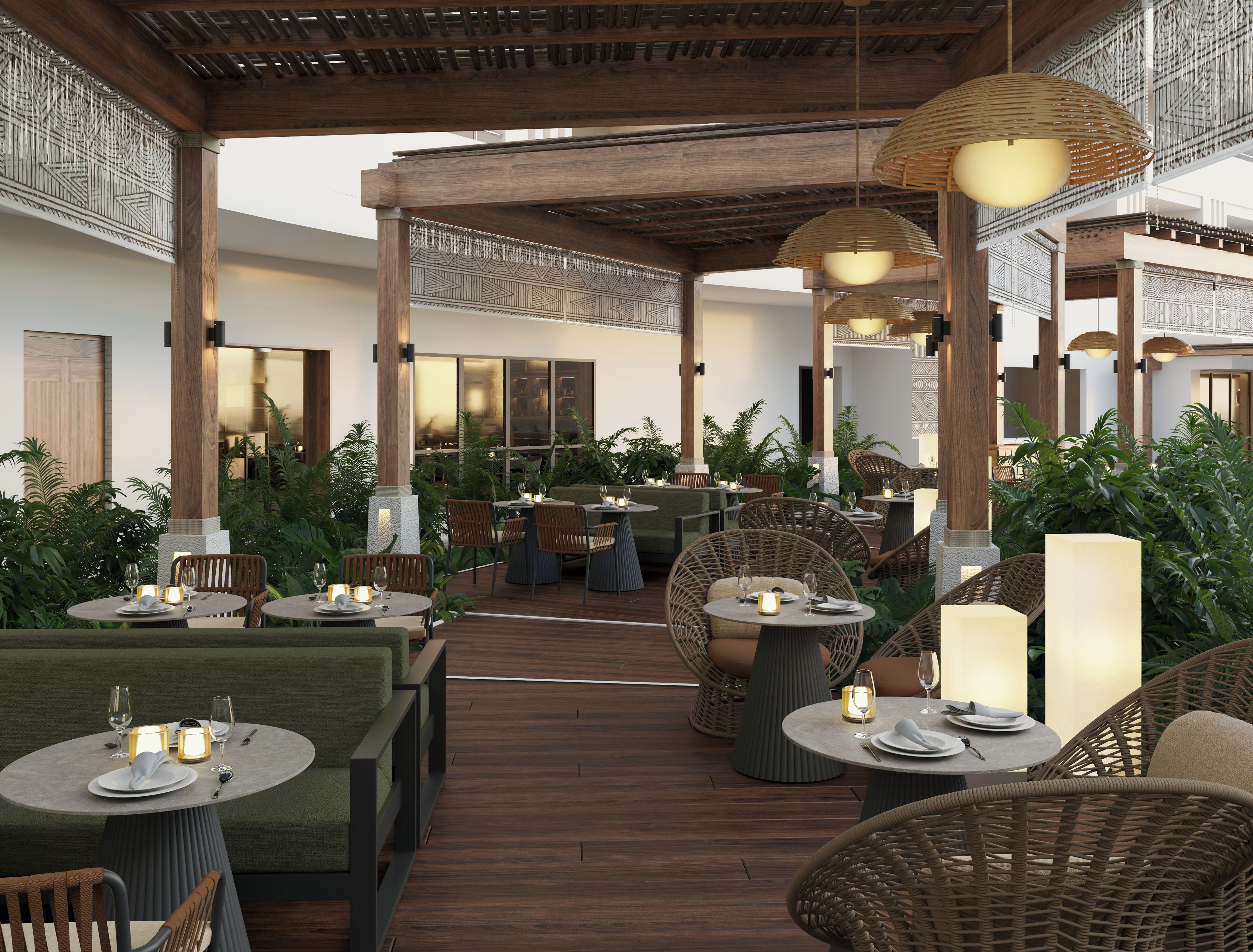 Un espace de restauration en plein air avec des tables rondes, des chaises en osier et un éclairage d’ambiance.