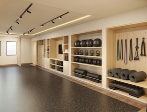 A gym with wooden lockers, weight plates, kettlebells, and exercise equipment. - Devossion By Live Aqua Celebration Resort & Spa Isla Mujeres (Isla Mujeres)