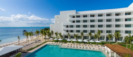 Una piscina al aire libre, sombrillas, sillones reclinables de piscina