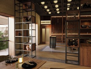 Un interior moderno con suelo de madera, una zona de comedor con una mesa lista para dos personas, y una estantería con diversos objetos.