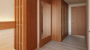 Un pasillo con puertas de madera y suelo de color claro.