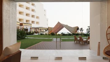 Um pátio moderno ao ar livre com deck de madeira, cadeiras de lounge e uma escultura geométrica única.