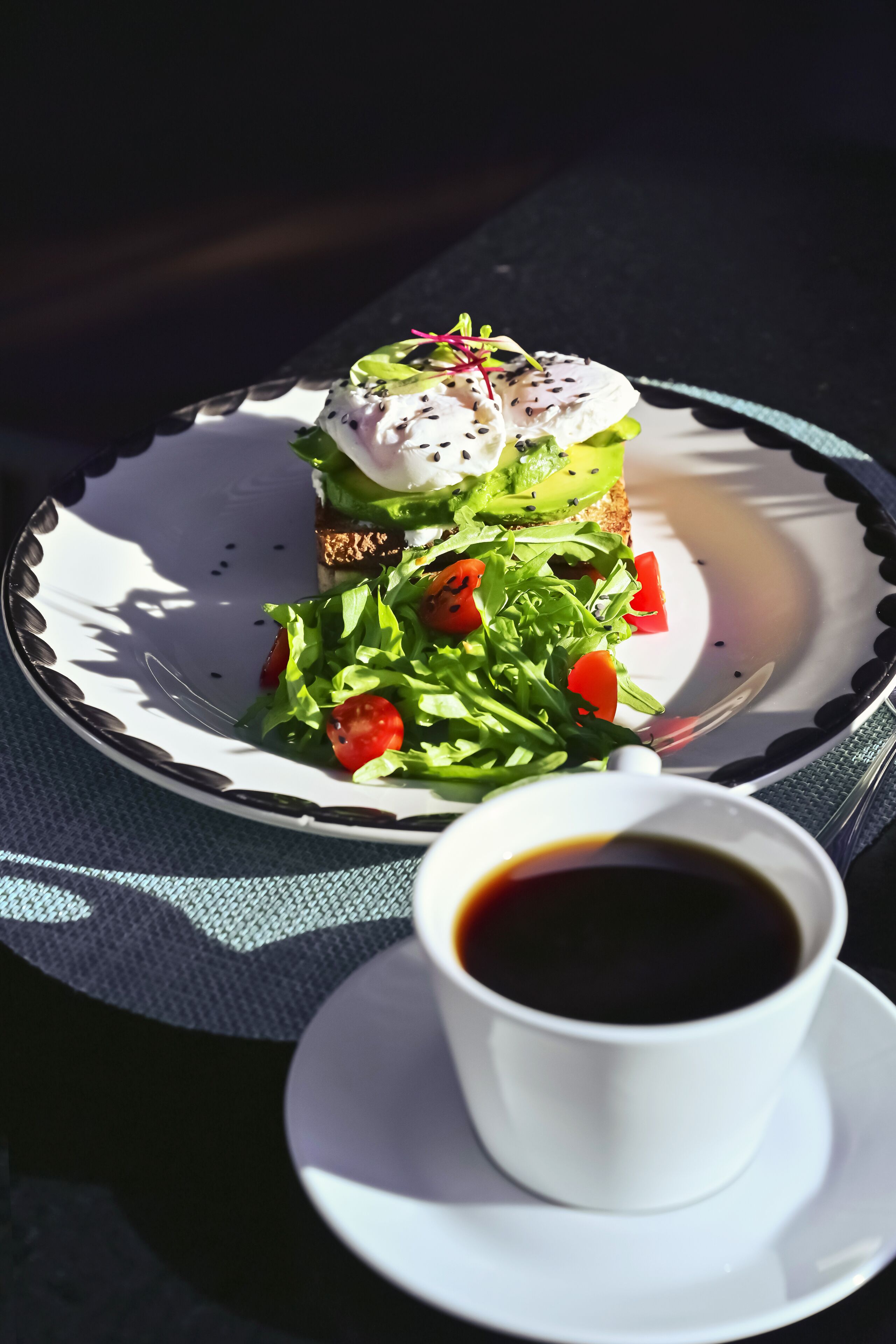 Ein Teller mit Salat, Brot und einer Tasse Kaffee auf einem Tisch.