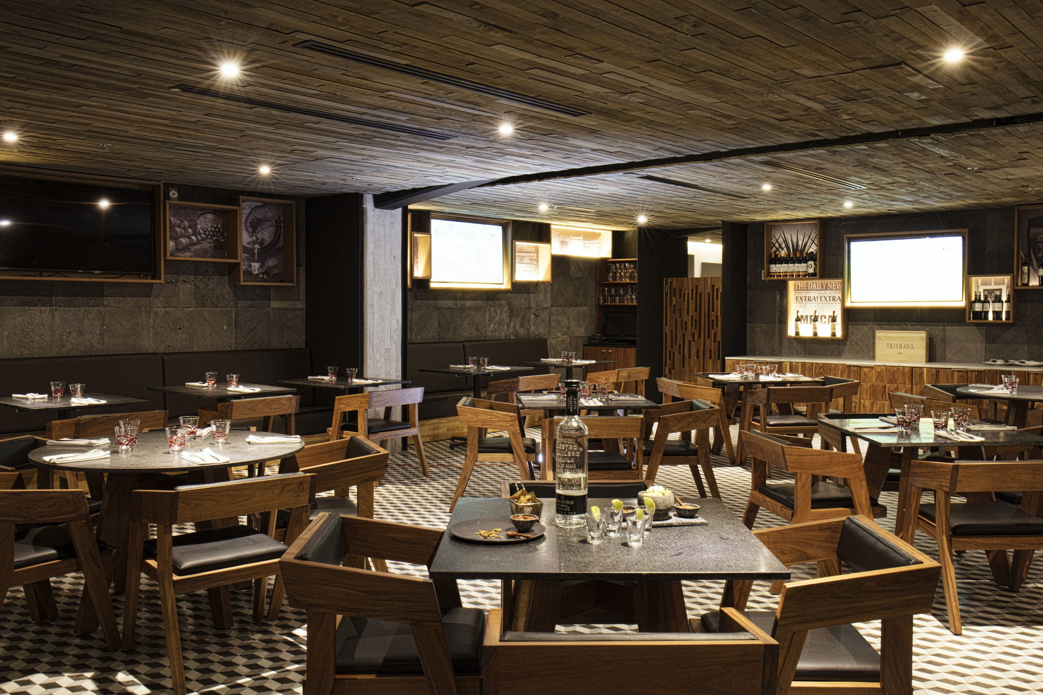A restaurant with wooden tables and chairs, a checkered floor, and framed artwork on the walls.