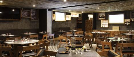 A restaurant with wooden tables and chairs, a checkered floor, and framed artwork on the walls.