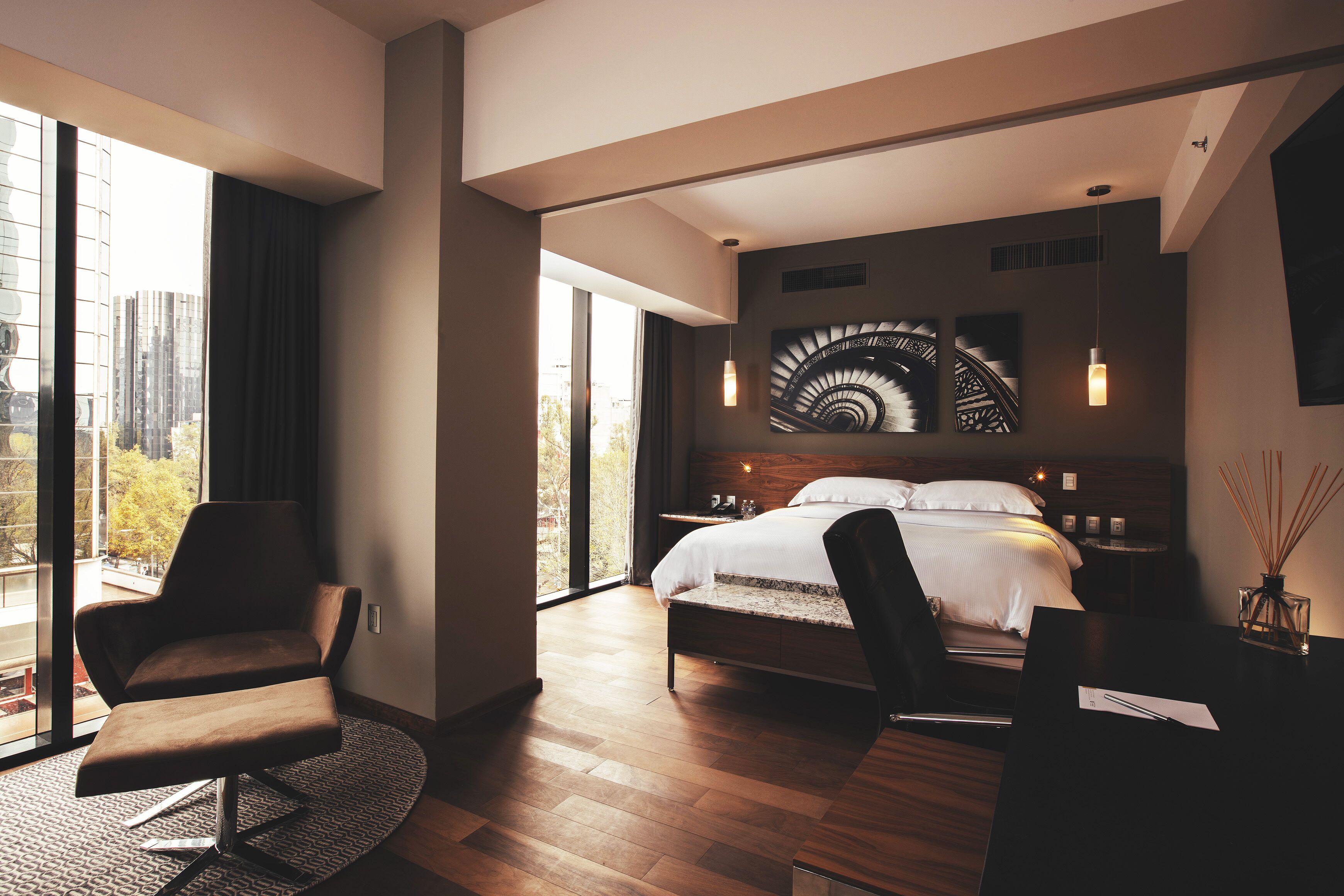 A modern bedroom with a large bed, a desk, and a chair.