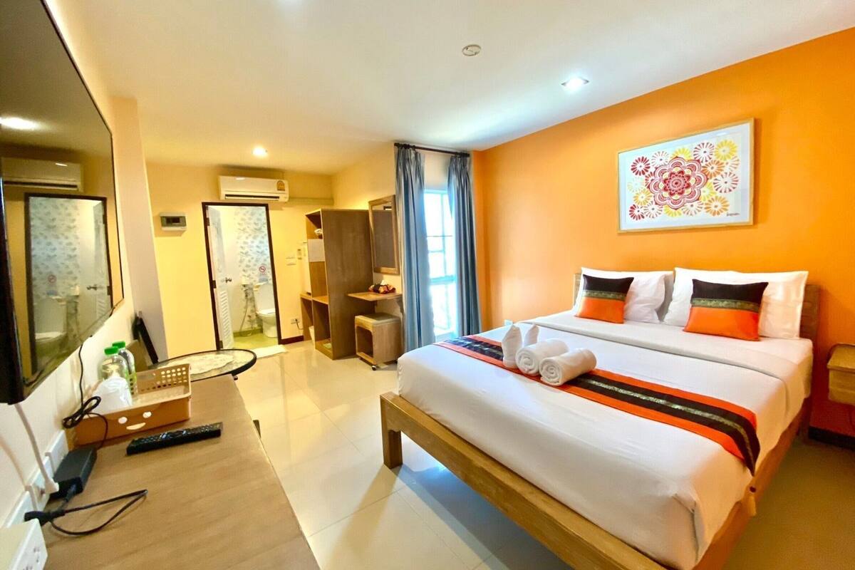 Une chambre d’hôtel comprenant un lit, un bureau, une chaise, un miroir et une salle de bain.