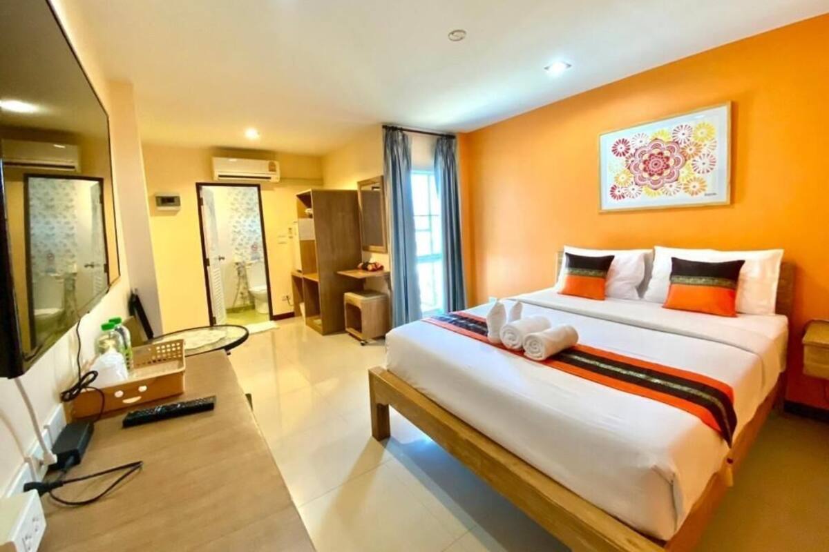 Une chambre d’hôtel avec un grand lit, un bureau et une télévision.