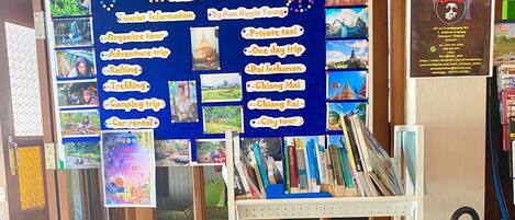 A travel information board with photos and text about tourist activities in Chiang Mai, including private taxi, city tour, and trekking.