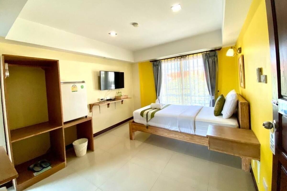 Une chambre d’hôtel équipée d’un lit, d’une télévision, d’un bureau et d’une armoire.