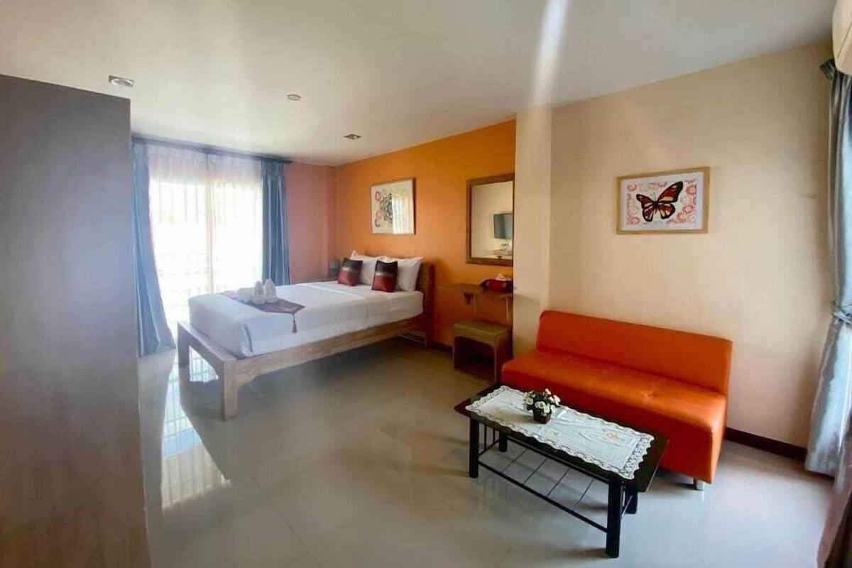 Une chambre d’hôtel comprenant un lit, un canapé, une table basse et des œuvres d’art accrochées aux murs.