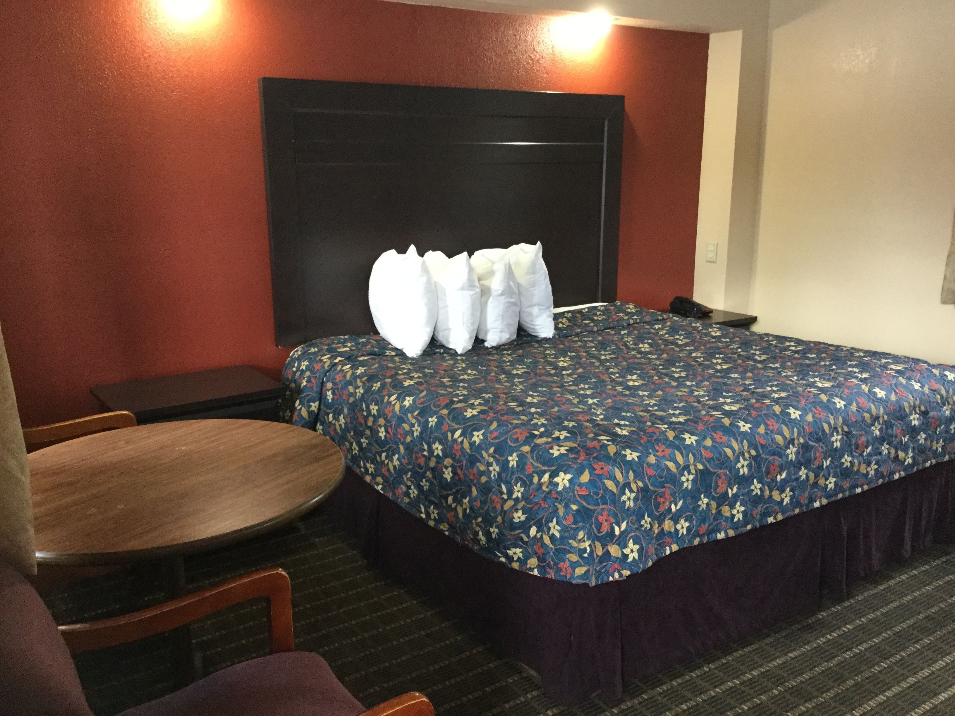Una habitación de hotel con una cama, una mesa redonda y dos sillas.