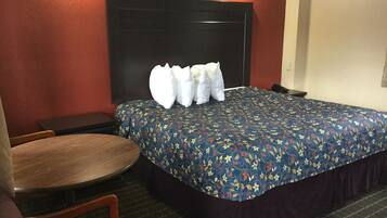 Una habitación de hotel con una cama, una mesa redonda y dos sillas.