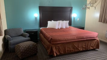 Relax in a spacious room with a large bed, nightstand, and comfortable chair.