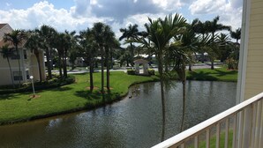 A residential area with a pond, palm trees, and a gazebo. - Melbourne Beach Condo - second floor - Lake view (Melbourne Beach)