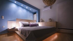 Ein modernes Schlafzimmer mit einem großen Bett, einem Holz-Kopfteil und einer blauen Akzentwand.