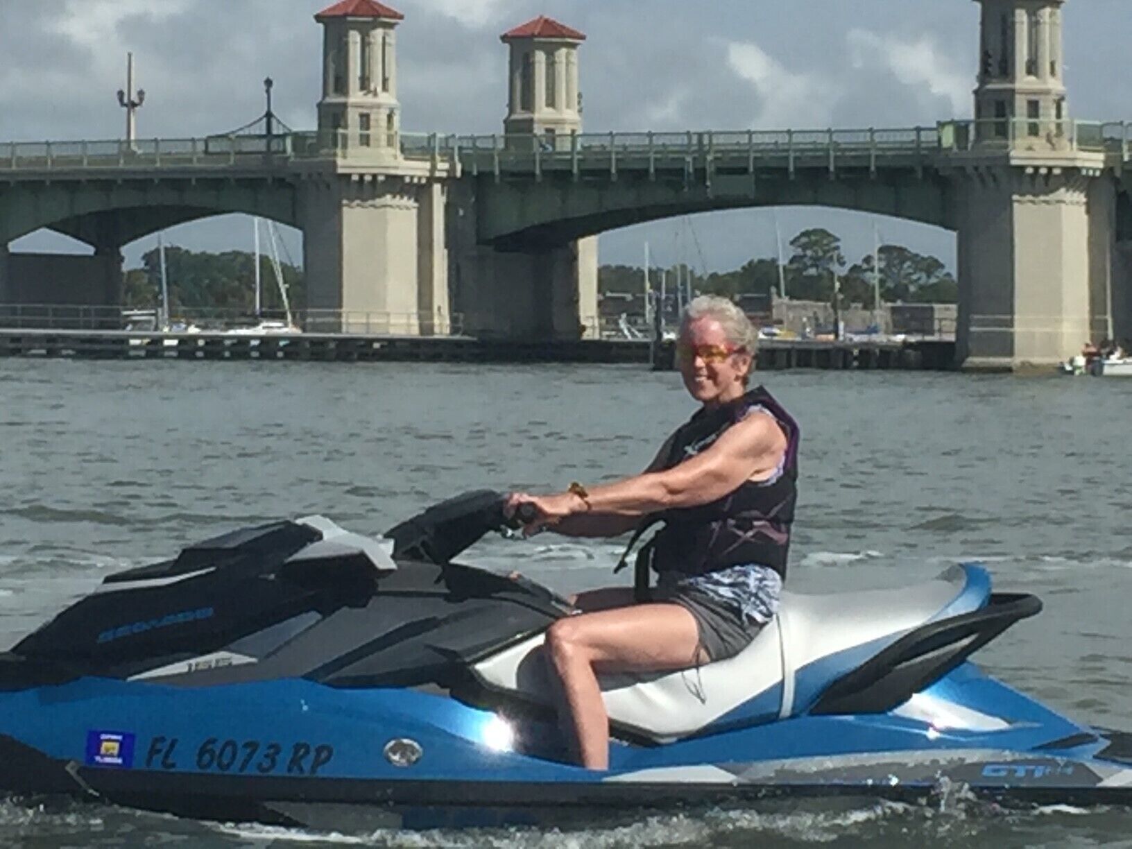 Iemand op een jetski, met een brug op de achtergrond.