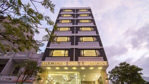 A multi-story hotel with a modern facade, illuminated signage, and a visible entrance with a glass door. - Salamander Hotel and Apartment (Da Nang)