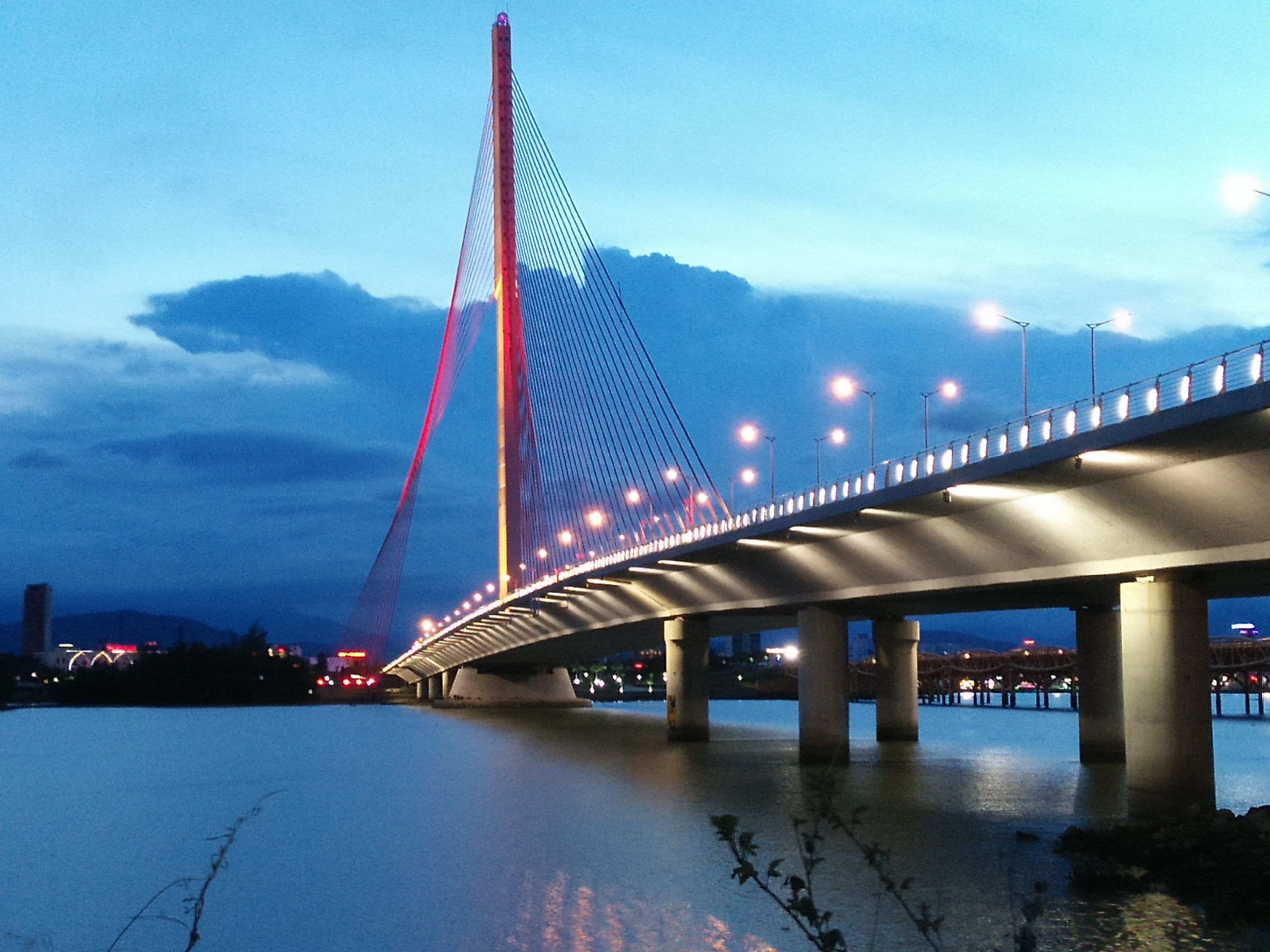 A cable-stayed bridge with multiple towers and a lit roadway.