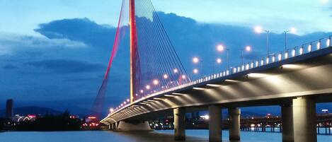 A cable-stayed bridge with multiple towers and a lit roadway.