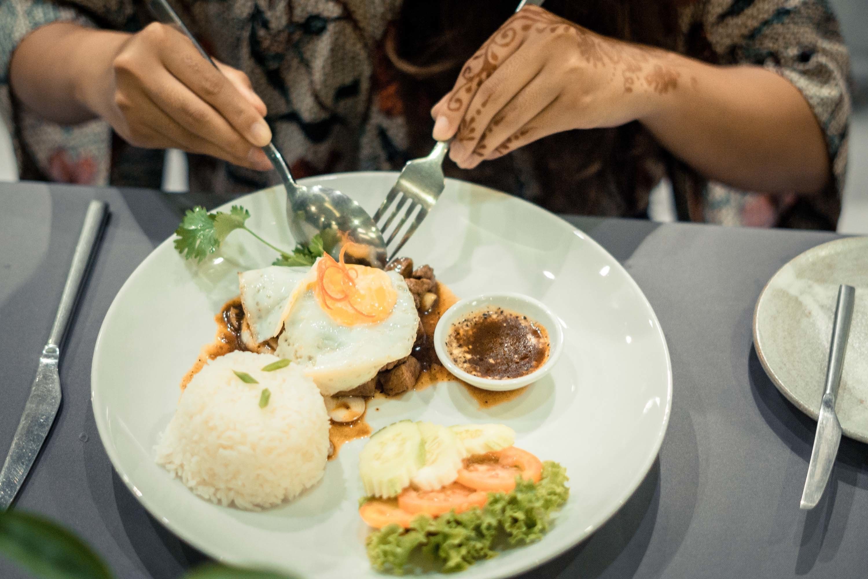 A plate of food with rice, vegetables, and a fried egg.