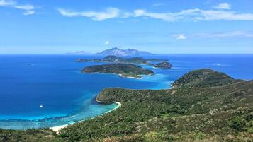 Un paisaje costero con varias islas y un cielo azul despejado.