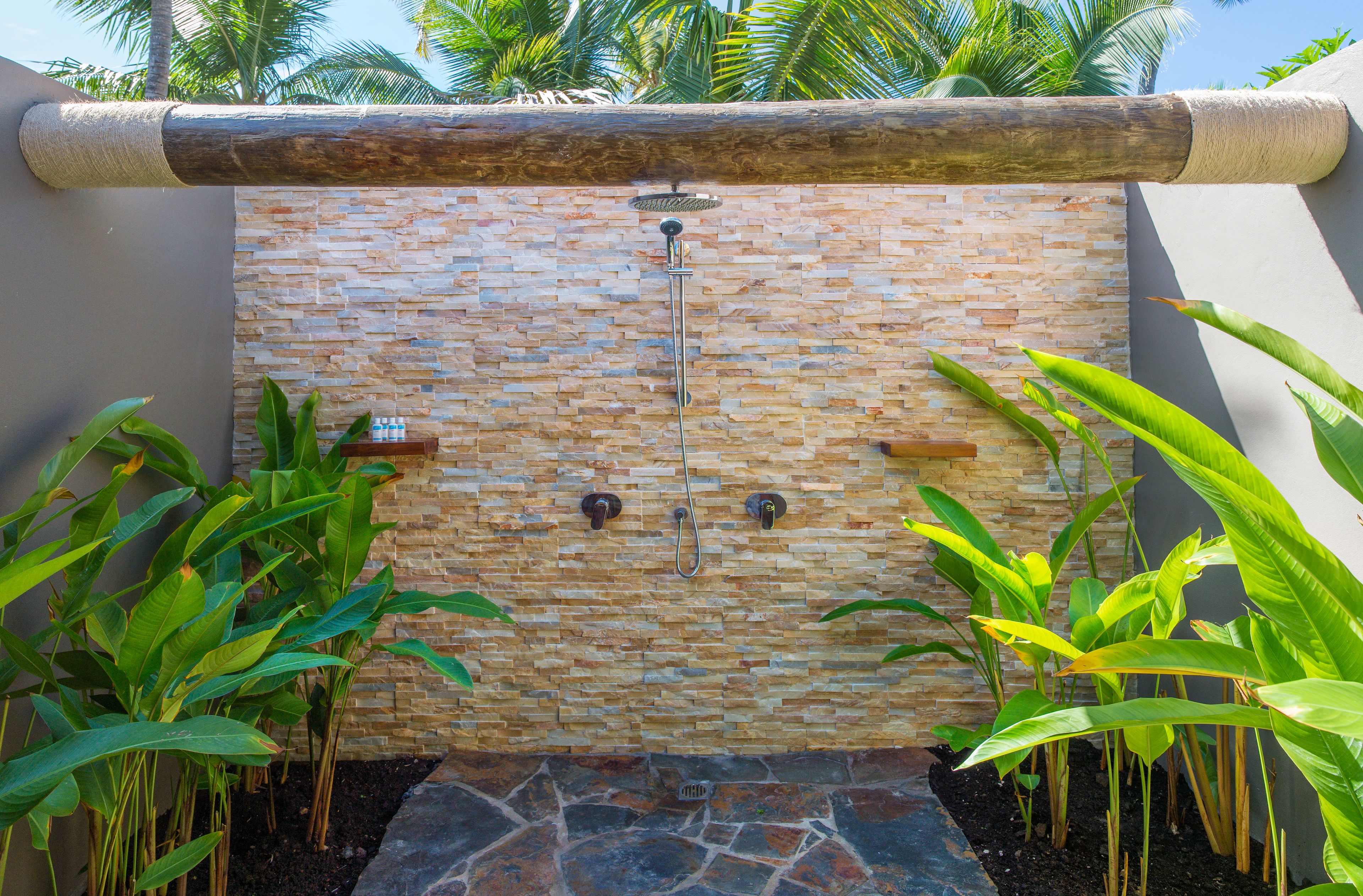 A stone wall with a water feature and two taps.