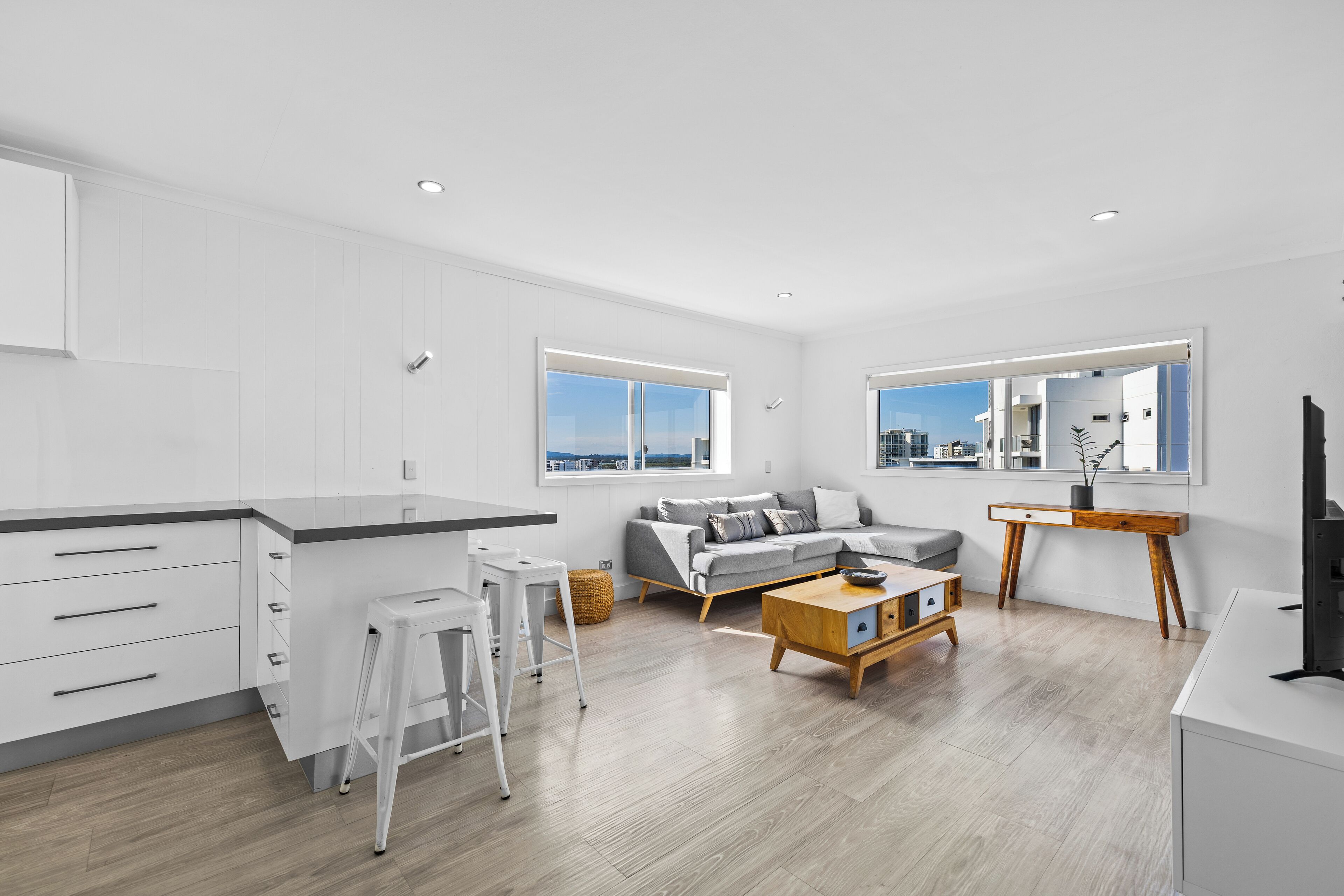 A modern apartment with a kitchen, living area, and large windows.