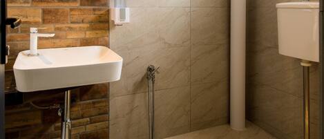 Un baño moderno con un lavabo rectangular, inodoro y zona de ducha.