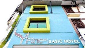 The exterior of the Fine Basic Hotel with a blue facade and two yellow-framed windows. - Finess Basic Hotel (Malacca City)