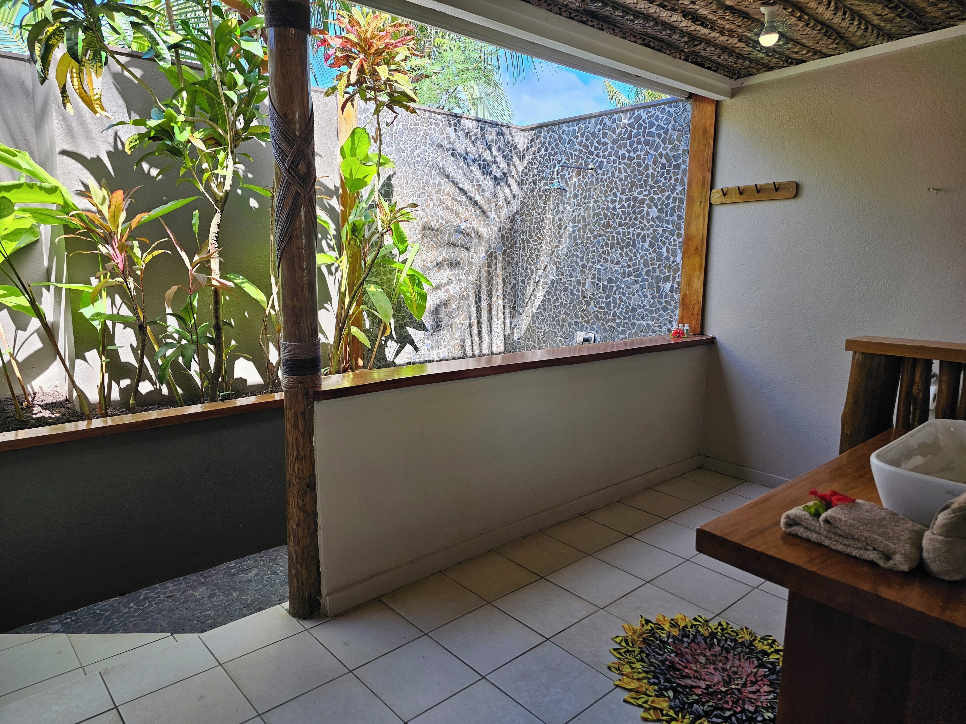 A room with a large window, a wooden table, and a tiled floor.