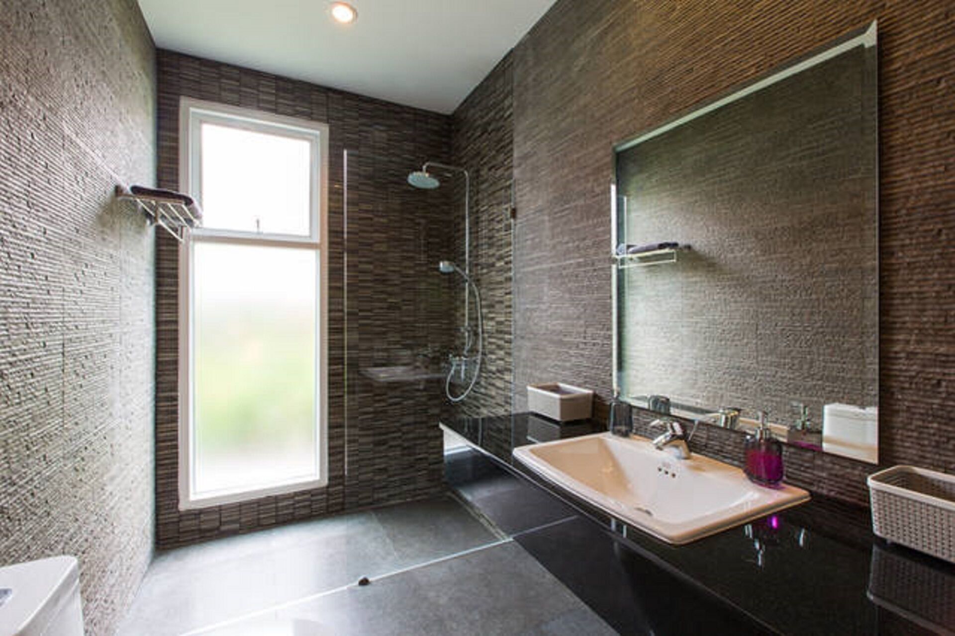 Een moderne badkamer met een grote spiegel, een bad en een wastafel.