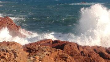 Une côte rocheuse où les vagues s’écrasent contre les rochers.