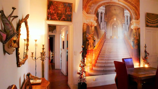 A grand staircase with a mural, ornate candelabras, and classical architecture. - "Diva"' apartment with unique atmosphere in a prime location (Nîmes)