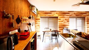 Una cocina moderna con detalles de madera, un comedor con mesa y sillas, y un horno empotrado.