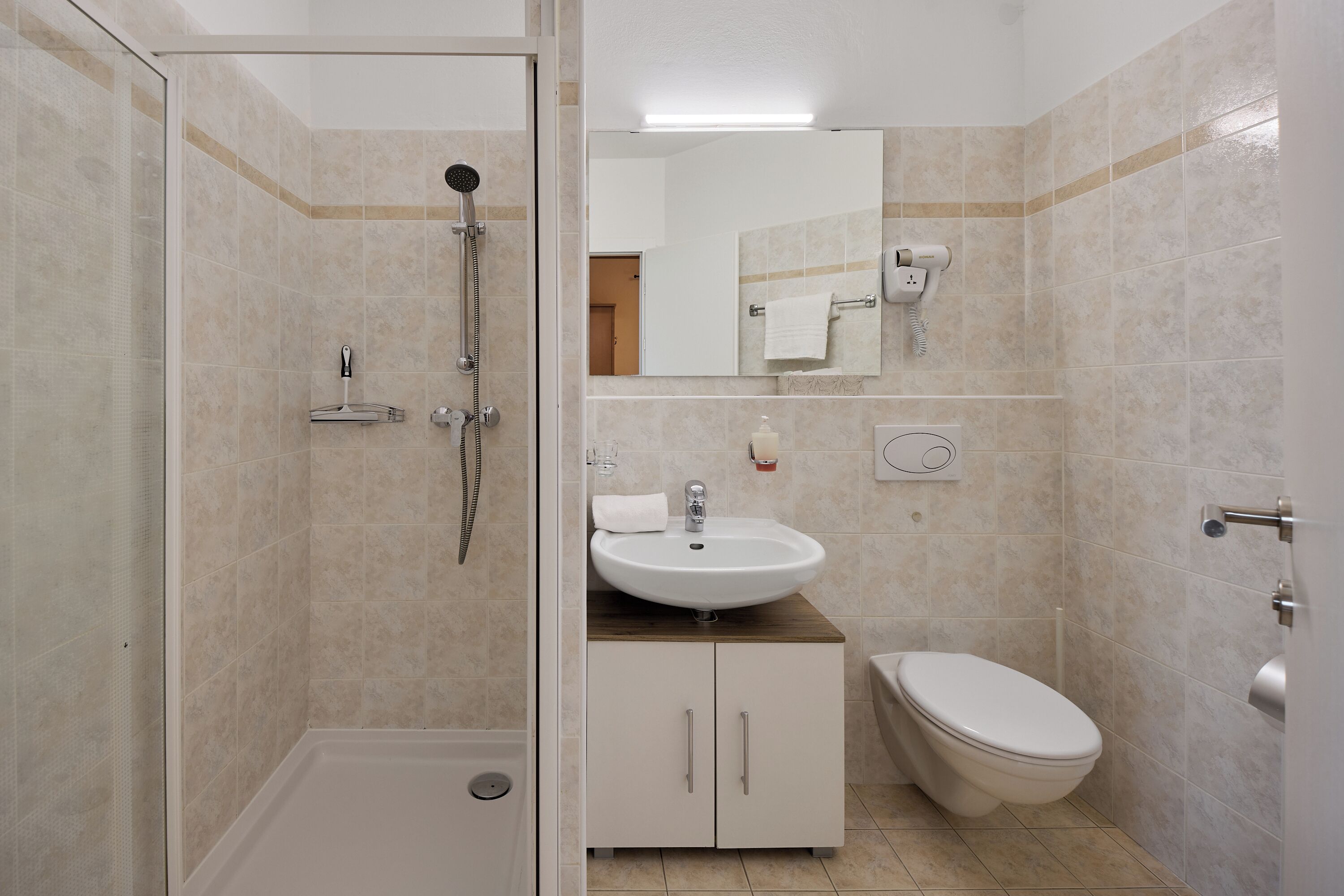 A bathroom with a shower, sink, and toilet.