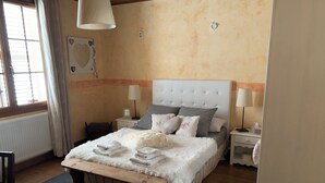Un dormitorio con cama, mesitas de noche, una ventana y un radiador.